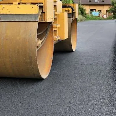 A road roller is being used for asphalt paving.