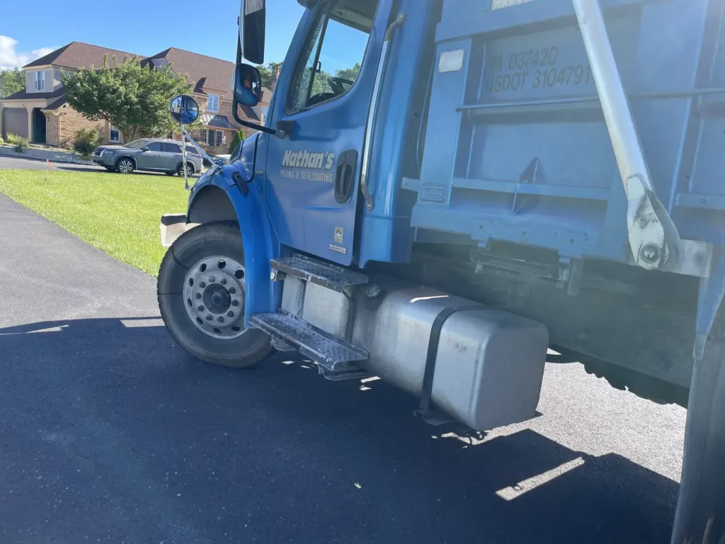 |||||||||||||A close-up of the driver's side of a blue truck labeled "Nathan's Paving & Sealcoating