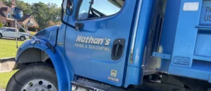 A close-up of the driver's side of a blue truck labeled "Nathan's Paving & Sealcoating