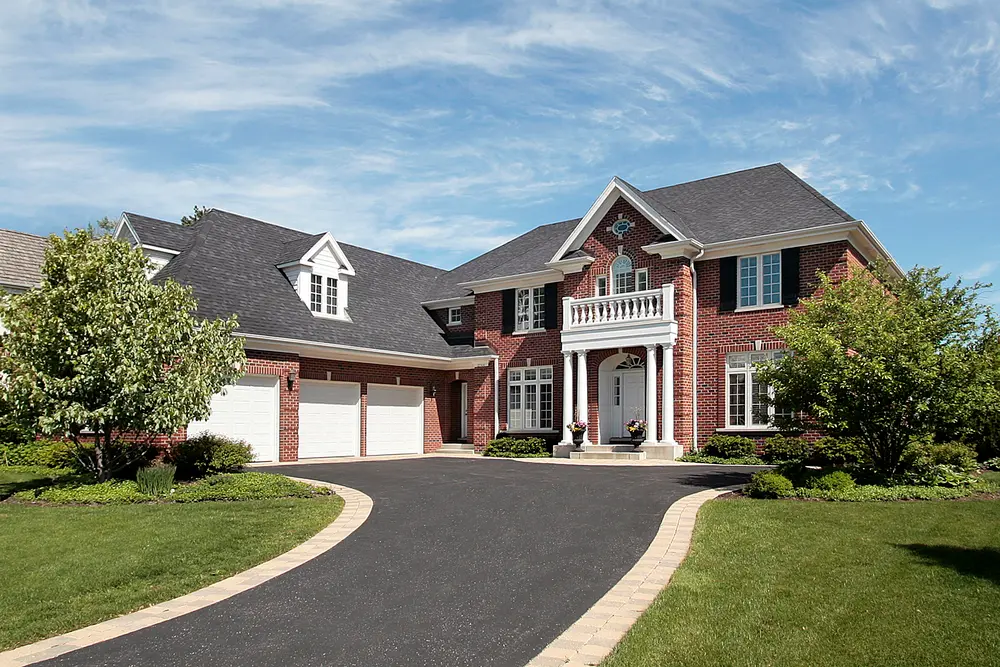 A large brick home with a driveway in Camp Hill