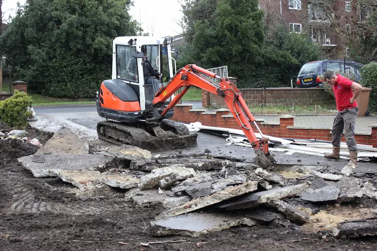 A man operating a bulldozer for driveway excavation on a construction site.