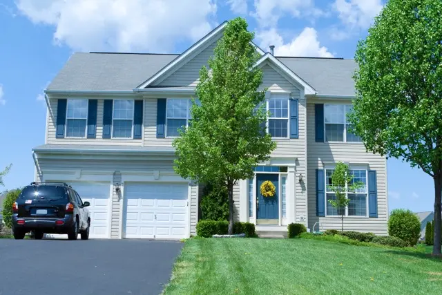 A house with a vehicle parked in front of it.