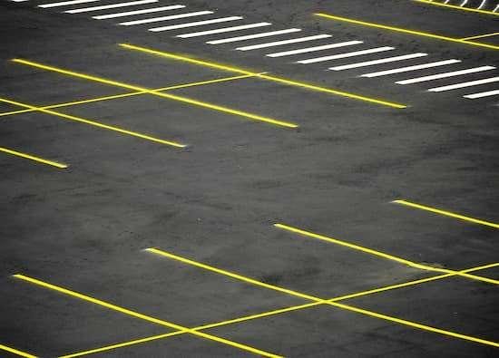 A new parking lot installation with freshly laid asphalt and clearly marked spaces.