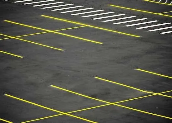 A new parking lot installation with freshly laid asphalt and clearly marked spaces.