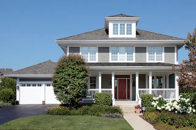 A charming home with a large front porch and a garage