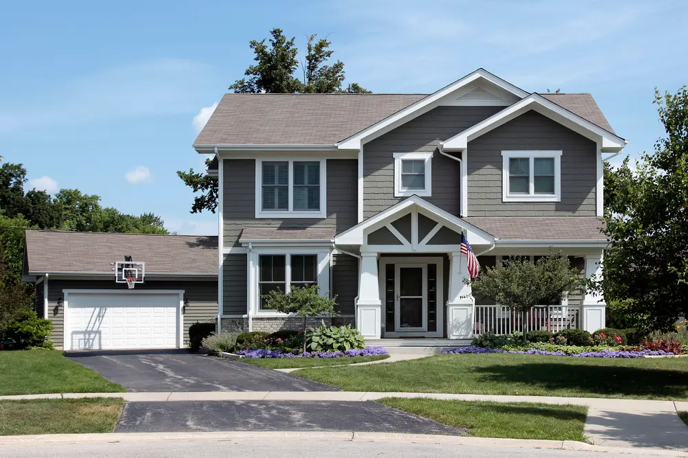 A home with gray siding and a preventative driveway maintenance.