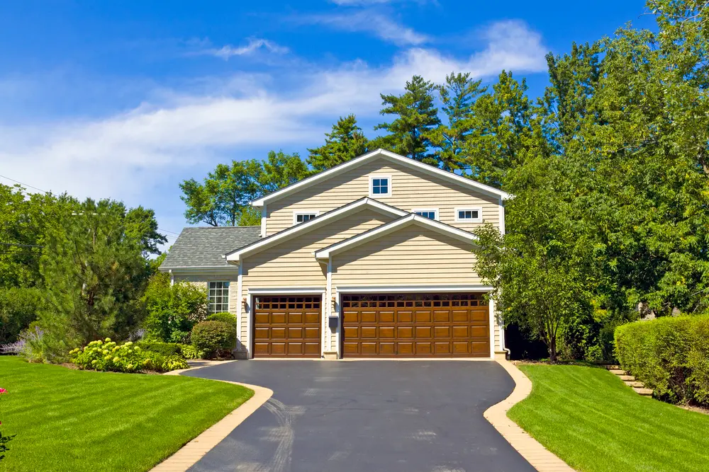 A residential driveway leading to a home with two garages