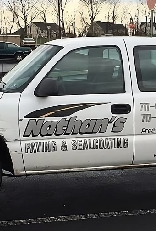 A Nathan’s Paving & Sealcoating truck parked on a freshly paved surface.