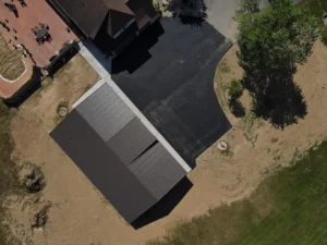 A newly paved driveway extension in Carlisle, featuring a smooth, dark surface and bordered by well-maintained grass. The extension seamlessly connects to an existing driveway, enhancing the property’s appearance.