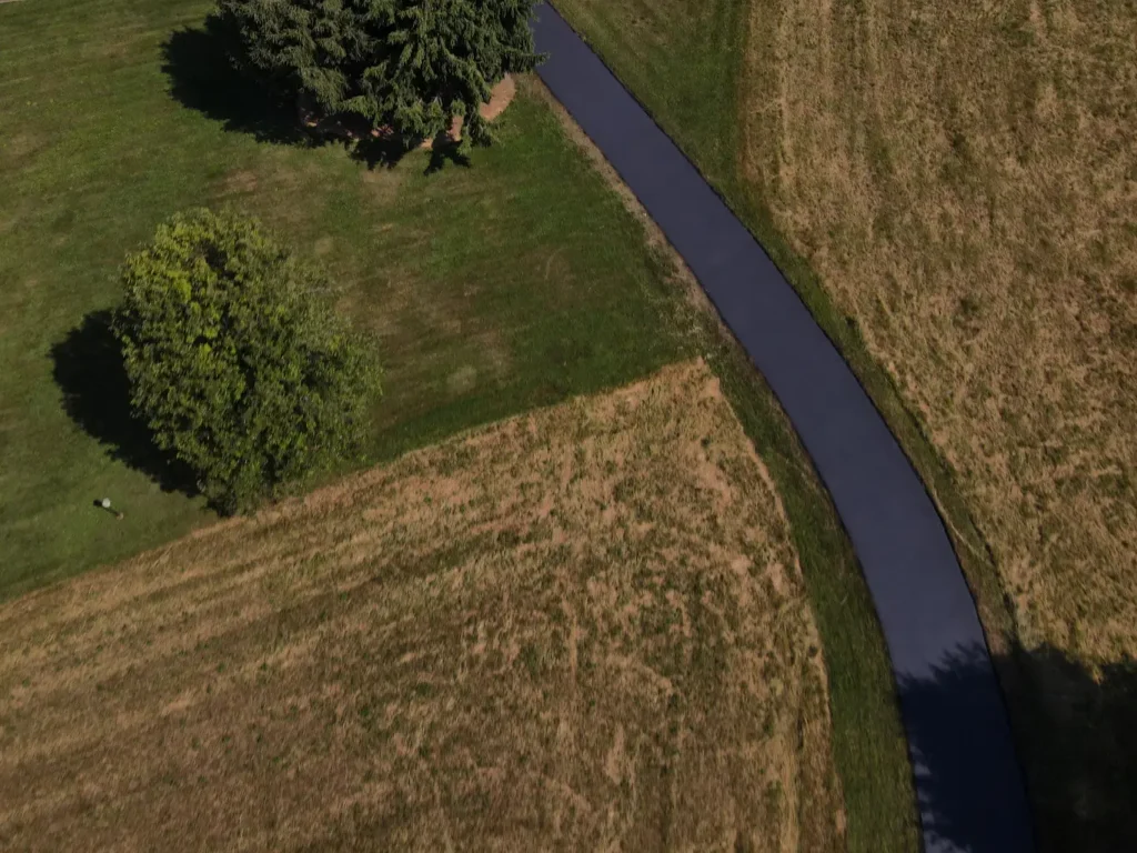 Alt text: A freshly sealed asphalt driveway in Carlisle, showing a smooth black surface with a slight sheen. The edges are clean and well-defined, enhancing the driveway's overall appearance.