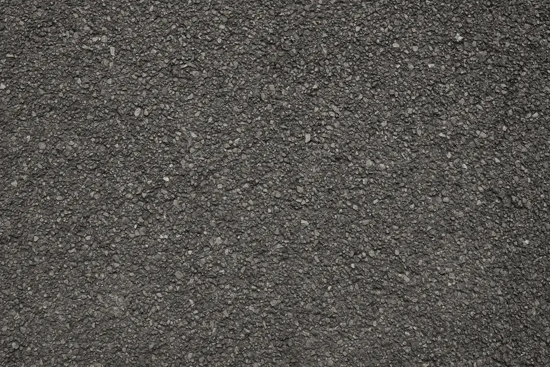 Close-up view of a smooth, freshly paved road with bright yellow dividing lines.