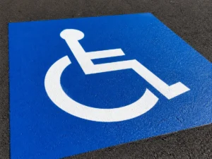 Blue and white painted symbol on pavement indicating a designated accessible parking space that meets ADA parking requirements in Pennsylvania for people with disabilities.